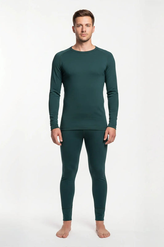 Man wearing a merino wool green thermal outfit on a white background