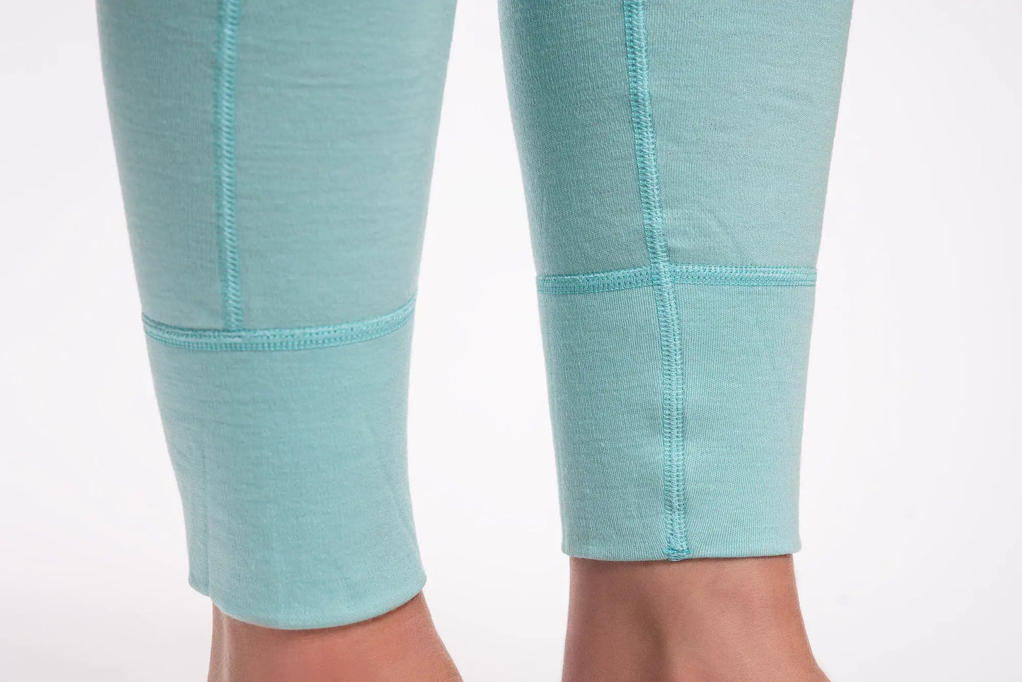 Close-up of teal merino leggings with a white background