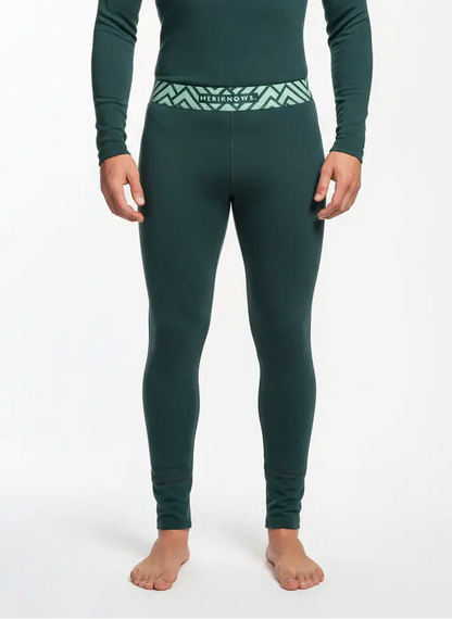 Person wearing green thermal merino wool leggings with a visible brand logo on a white background