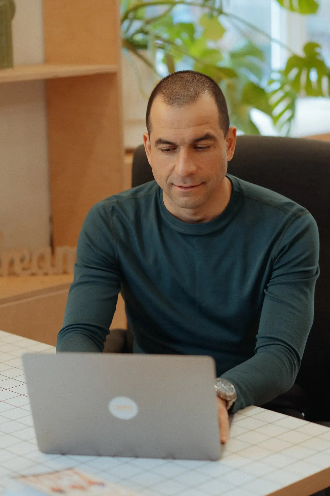 Man in green merino top for everyday use works in his office