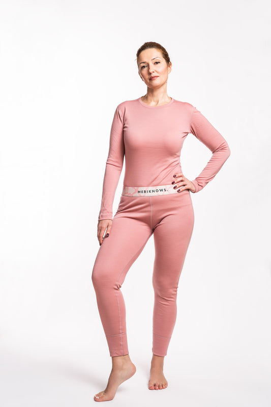 Woman wearing a pink long-sleeve merino top and pants on a white background