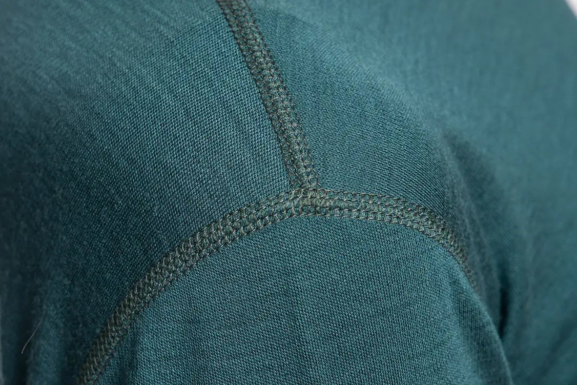 Close-up of teal fabric merino wool with flat lock seam