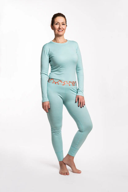 Woman wearing a light blue long-sleeve merino top and leggings on a white background